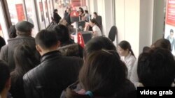 Очередь желающих снять свои депозиты на волне слухов о предстоящем банкротстве нескольких коммерческих банков. Алматы, 18 февраля 2014 года.