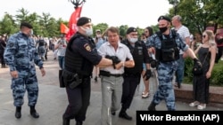 Ofițerii de poliție rețin un demonstrant în timpul unui protest anti-vaccin din centrul Moscovei, Rusia, 26 iunie 2021.