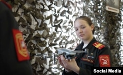 A girl holds a drone inside a school museum in Moscow.