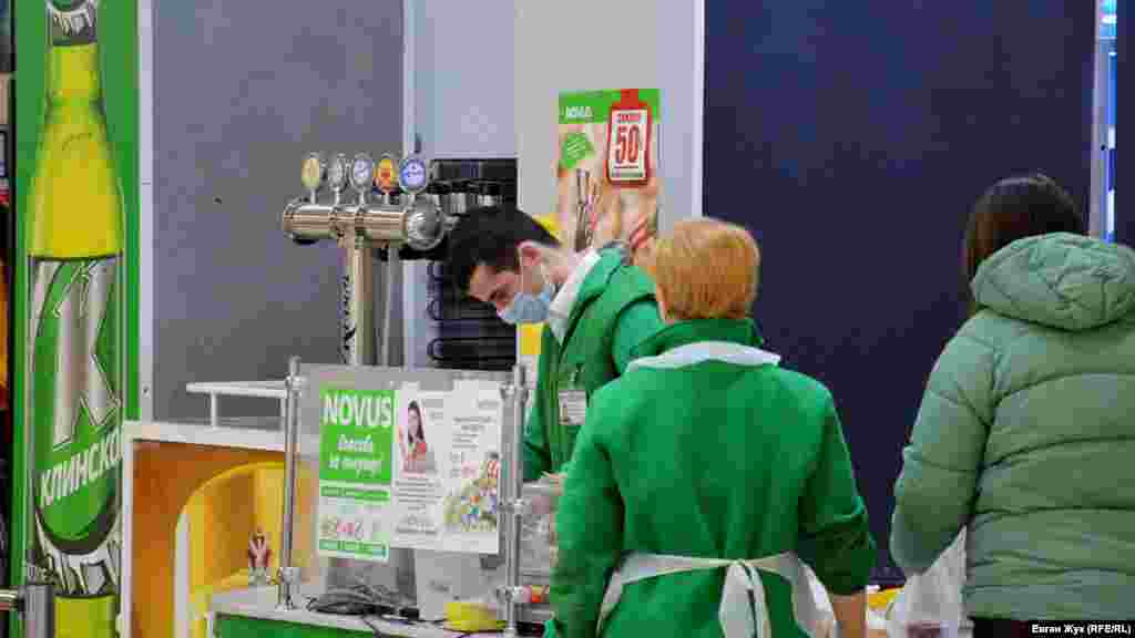 Кассир в супермаркете Novus работает в медицинской маске