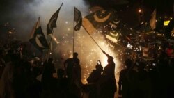 Pakistanis in Hyderabad wave flags as they celebrate after a cease-fire between Pakistan and India.