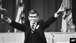 Bruce Laingen, former charge d'affairs at the U.S. Embassy in Tehran, waves a flower and "V" sign at the close of a press conference in West Point on January 27, 1981.