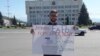 Пикет сторонника КПРФ против "Единой России" во Владикавказе на фоне мэрии города