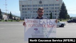 Пикет сторонника КПРФ против "Единой России" во Владикавказе на фоне мэрии города