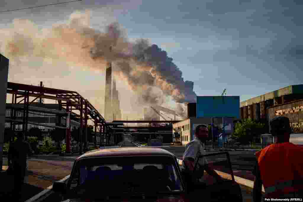 Coke plant security staff inspect a passing car. The plant is not working at full capacity.