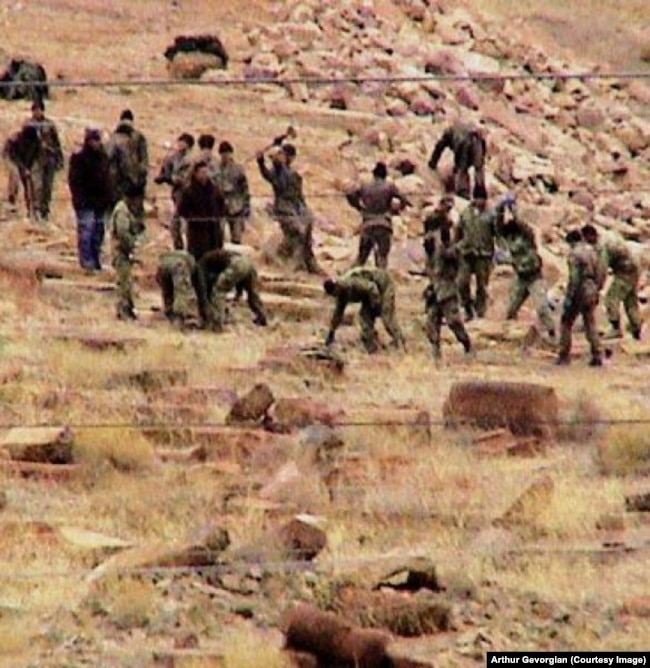 Men working with sledgehammers at the Julfa cemetery in December 2005.