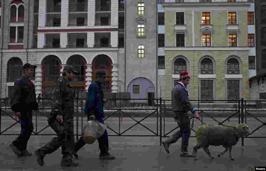 Migrant workers walk with a sheep through the village of Krasnaya Polyana, a venue for the 2014 Winter Olympics some 40 kilometres outside Sochi, in September 2013.&nbsp;