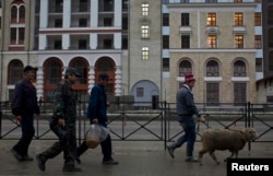 Punëtorët migrantë shihen me një dele në Krasnaja Poljana, afër qytetit jugor të Soçit.