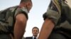 French President Nicolas Sarkozy (center) speaks with troops in Afghanistan on August 20 after 10 French soldiers were killed.