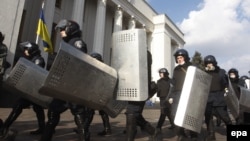 Ukrainian riot police leave the area around the country's parliament on February 21 after an agreement was reached between opposition leaders and President Yanukovych on February 21 to resolve the country's political crisis. 