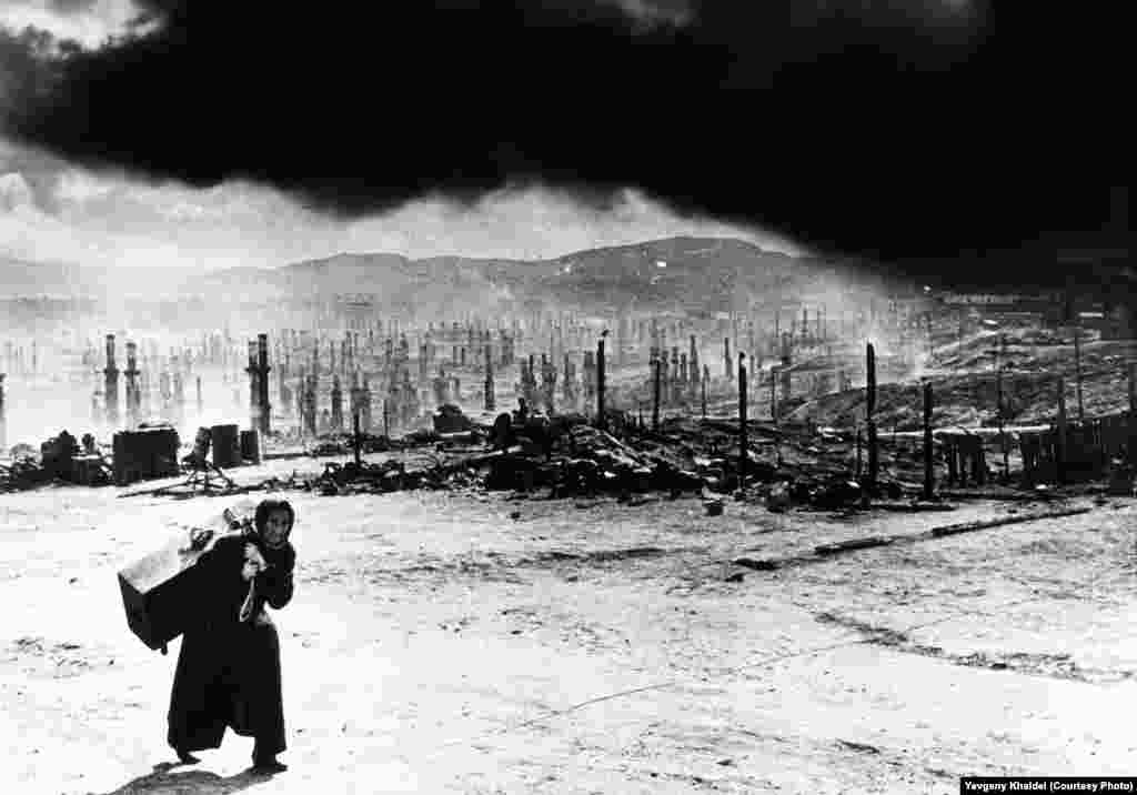 A woman flees Murmansk, in northern Russia, as the city is devastated following Hitler's order to burn it to the ground in late June 1942