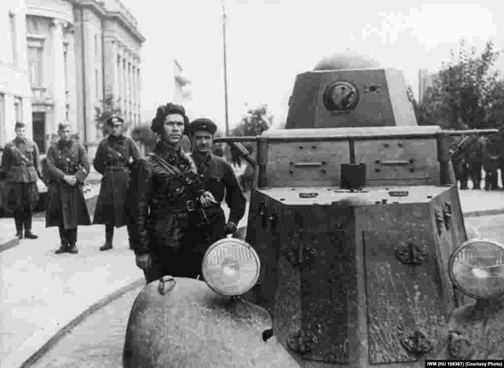 Soviet Commissar Borovitsky and one of his soldiers stand beside an armored car in Brest.