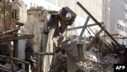 Men inspect the damage from a blast near the Finance Ministry on December 9.