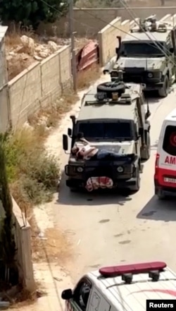 Armata israeliană a legat un palestinian pe un jeep militar în timpul raidului din Jenin, în Cisiordania ocupată de Israel, 22 iunie 2024. REUTERS/Reuters TV