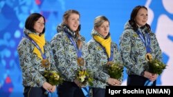 Чемпіонки Олімпійських ігор-2014 в естафетній гонці, члени жіночої збірної України з біатлону Віта Семеренко, Юлія Джима, Валентина Семеренко та Олена Підгрушна (крайня праворуч) під час церемонії нагородження на XXIІ зимових Олімпійських іграх, Сочі (Росія), 22 лютого 2014 року