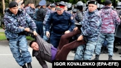 Полиция задерживает людей во время акции протеста, призывающей к свободным и справедливым выборам во время президентских выборов в Нур-Султане. Казахстан, июнь 2019 года.