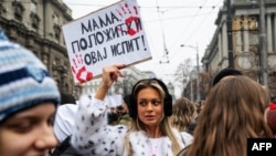  Студент държи афиш с надпис „ Мамо, ще устоя този изпит “, до момента в който стачкуващи се събират пред постройката на държавното управление в центъра на Белград на 24 януари 2025 година 