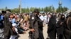 نیروهای طالبان در حالی که افغان‌های اخراج‌شده از ایران منتظر دریافت کمک‌های غذایی در هرات هستند، نگهبانی می‌دهند. ۴ اگست ۲۰۲۵