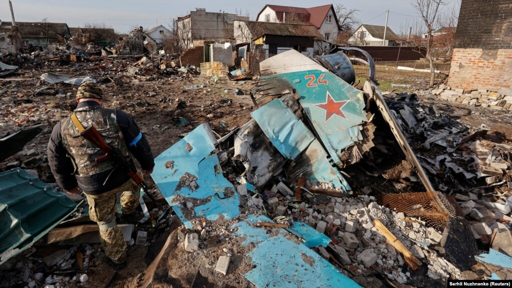 Військовослужбовець ЗСУ оглядає залишки російського бойового літака Су-34 в житловому районі Чернігова, 6 квітня 2022 року