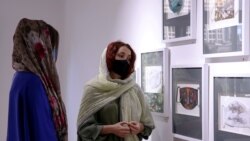 Коронавирустан қатты зардап шеккен Иранда әйел адам маска тақырыбындағы картиналарды тамашалап тұр. Тегеран, Иран. 18 шілде, 2020 жыл.