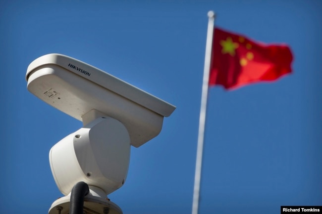 Një kamerë e Hikvisionit e vendosur pranë një flamuri kombëtar kinez.