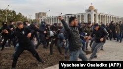 Сторонники Садыра Жапарова бросают землю с клумбы в сторону сторонников бывшего президента Кыргызстана Алмазбека Атамбаева во время митинга в Бишкеке. 9 октября 2020 года.