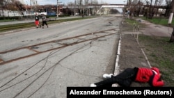 The body of a civilian killed during the Russian invasion lies in a street in the southern port city of Mariupol in April 2022.