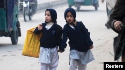 Two girls walk to school in Peshawar.