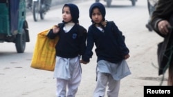 Two girls walk to school in Peshawar.