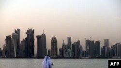Qatar -- A man looks at his phone on the corniche in the Qatari capital Doha , July 2, 2017