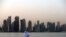 A man looks at his phone on the corniche in the Qatari capital Doha on July 2