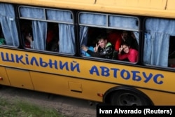 Gyerekeket evakuálnak egy iskolabuszban az oroszok által megszállt Kupjanszk városából Harkiv külvárosában május 30-án