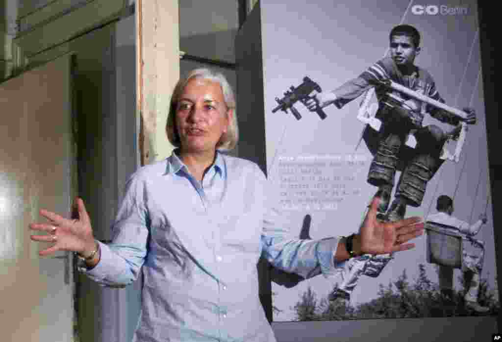 Anja Niedringhaus stands in front of a photo she took in Afghanistan as she answers journalists&#39; questions during a press preview of her exhibition, &quot;Anja Niedringhaus At War,&quot; at a gallery in Berlin,&nbsp;December&nbsp;14,&nbsp;2011.