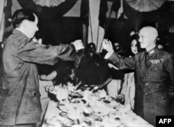  Лидерът на китайските комунисти Мао Дзедун (вляво) подвига тост с водача на националистите Чан Кайшъ в края на Втората международна война през 1945 година 