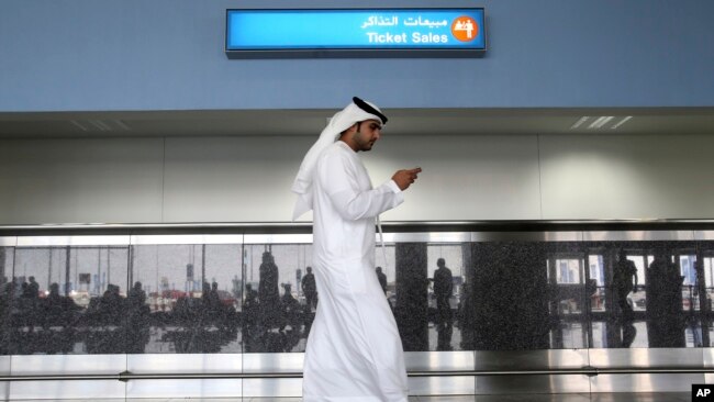 یک کارگر در فرودگاه بین‌المللی آل مکتوم دبی در حال استفاده از اپلیکیشن چت «توتاک» (ToTok)، اپلیکیشنی که به نوشته آسوشیتدپرس در واقع یک ابزار جاسوسی حکومت امارات برای ردیابی شهروندان است