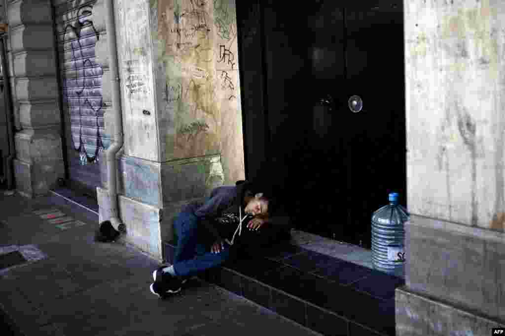 A young migrant sleeps on Omonia Square in downtown Athens. (AFP/Angelos Tzortzinis)