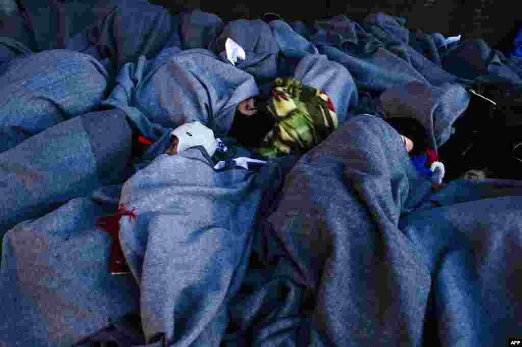 Migrants and refugees sleep on the shore after arriving on the Greek island of Lesbos after crossing the Aegean Sea from Turkey. (AFP/Dimitar Dilkoff)