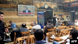 Syrians watched the speech of President Bashar al-Assad on television at a cafe in Damascus on January 10.