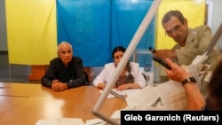 UKRAINE -- Members of a local electoral commission empty a ballot box at a polling station after a parliamentary election in Kyiv, Ukraine July 21, 2019