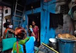 Медқызметкер Мумбайдың кедейлер тұратын ауданындағы тұрғындардың Covid инфекциясын жұқтырған-жұқтырмағанын тексеру үстінде. Үндістан, 6 шілде 2020 жыл.