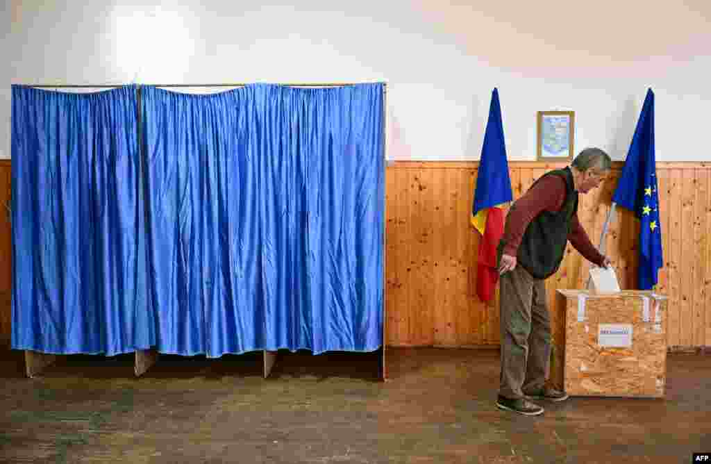A voter casts his ballot at a polling station in Persani, central Romania, on May 18, 2025, during the second round of the presidential elections.