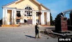 Un militar ucrainean lângă monumentul distrus al lui Vladimir Lenin din localitatea Suzh, regiunea Kursk, Rusia, 21 august 2024.