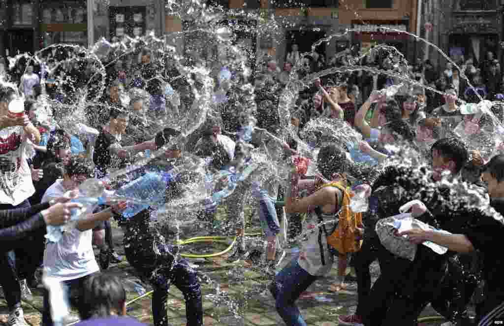 Young Ukrainians pour water on each other on a street in Lviv. The tradition of pouring water is an ancient spring ritual of cleansing that takes place on the first Monday after Orthodox Easter. (epa/Ivan Boberskyy)