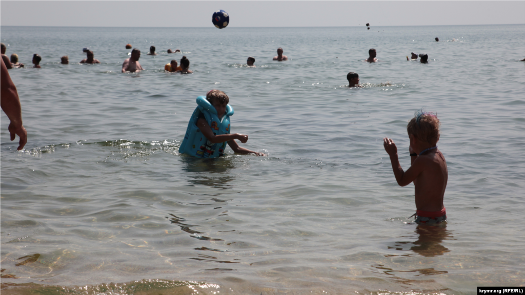 Дети играют в мяч в море