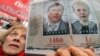 A woman holds a placard with pictures of jailed ex-premier Yulia Tymoshenko and jailed opposition leader Yuriy Lutsenko.