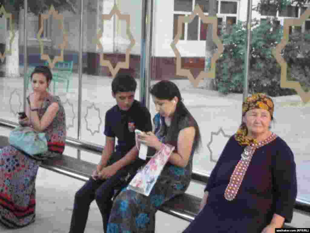 Aşgabadyň awtobus duralgasyndaky adamlar