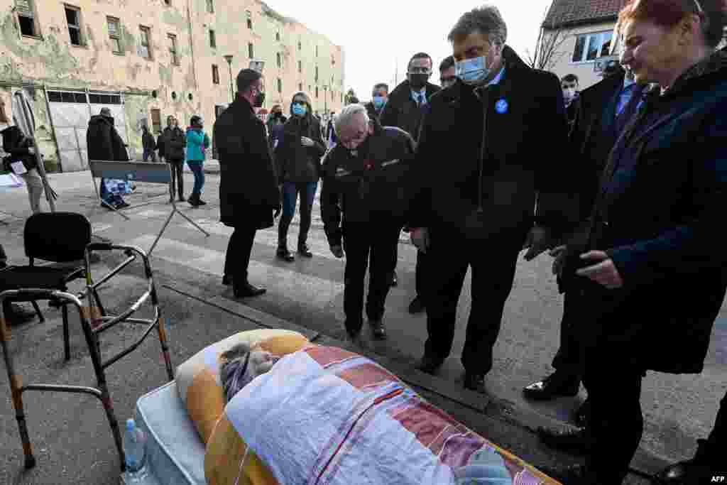 Хрватскиот премиер Андреј Пленковиќ гледа во постара жена која беше евакуирана од нејзиниот демолиран стан во Петриња, на околу 50 километри од Загреб, откако градот го погоди земјотрес со јачина од 6,4 степени на 29 декември 2020 година