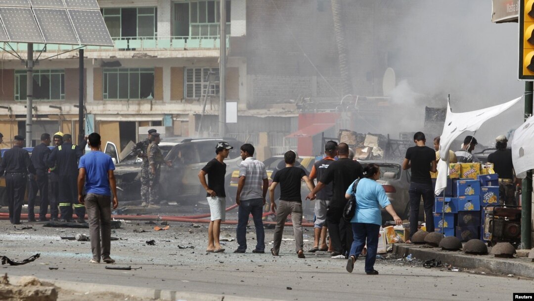 Iraqis gather at the site of a bomb attack in central Baghdad on July 31.