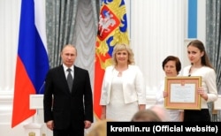 Владимир Путин вручает грамоту «Город воинской славы» представителям Феодосии