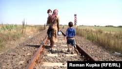 A mother and her children, pictured in 2015, walk across the border from Serbia to Hungary. 
